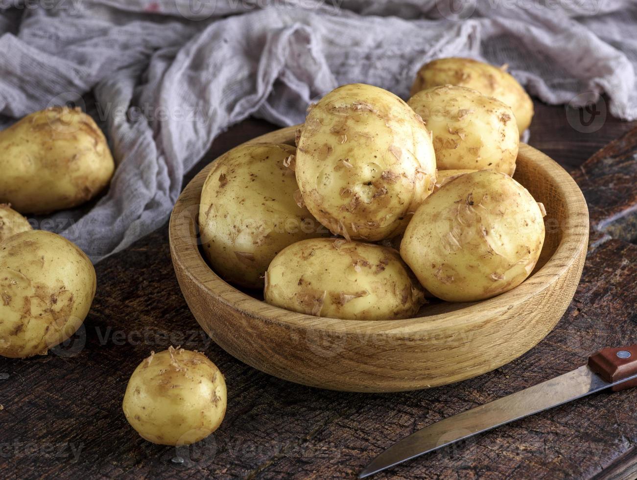 Kartoffeln in der Schale lagen in einer Holzschale auf einem braunen Tisch foto