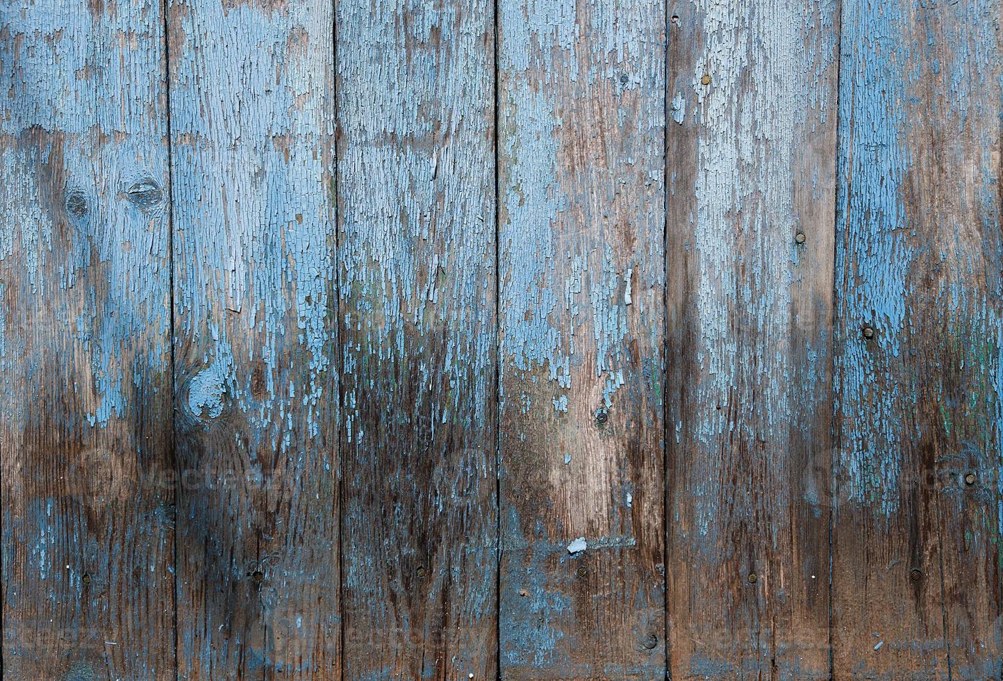 sehr alter hölzerner hintergrund mit blauer rissiger farbe, parallelen brettern foto