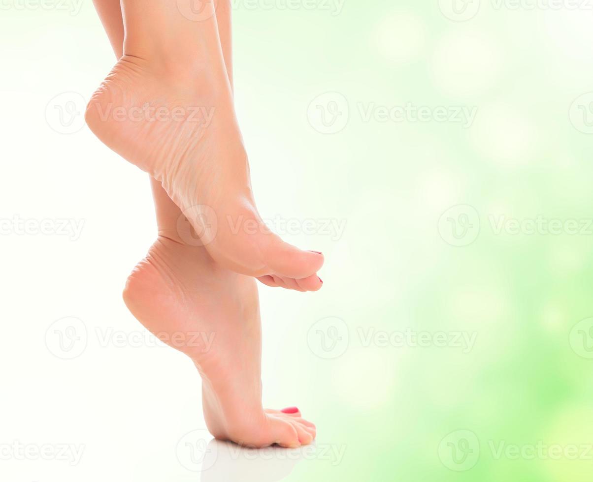 weibliche füße auf unscharfem grünem hintergrund foto