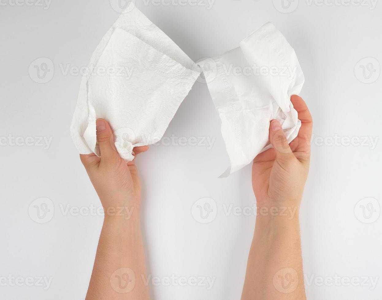 weibliche hände, die eine saubere weiße papierserviette für gesicht und körper halten foto