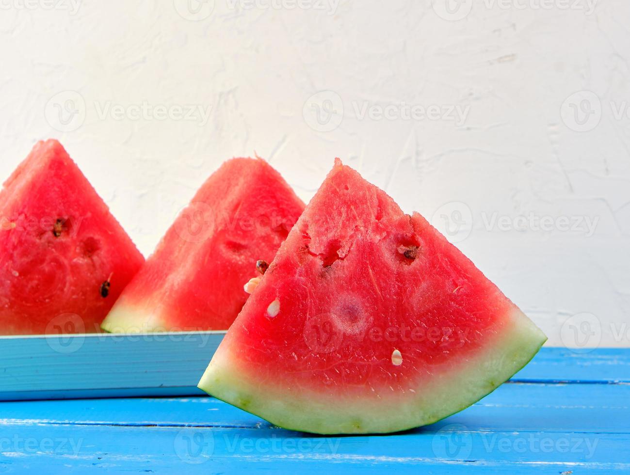 in Scheiben geschnittene Dreiecke reife rote runde Wassermelone mit Samen foto