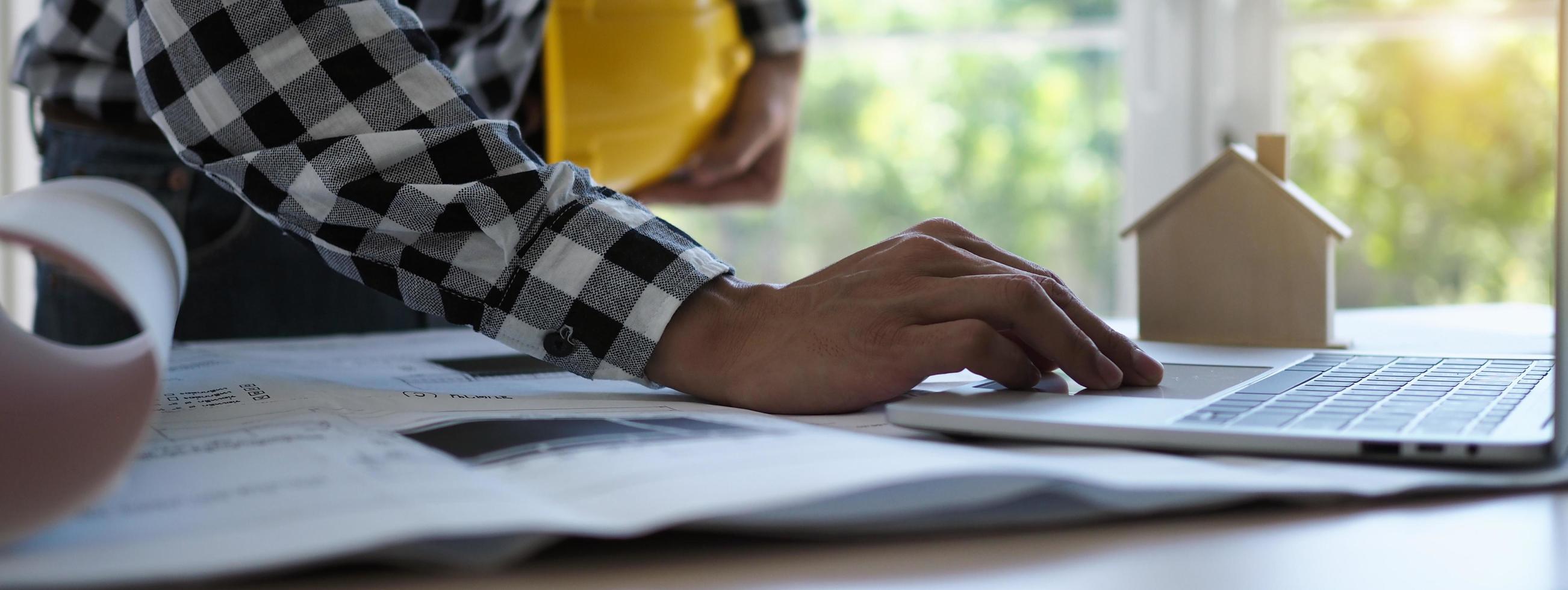 Ingenieure verwenden Laptops und überprüfen den Bauplan. Bauvorhabenplanung erstellen foto