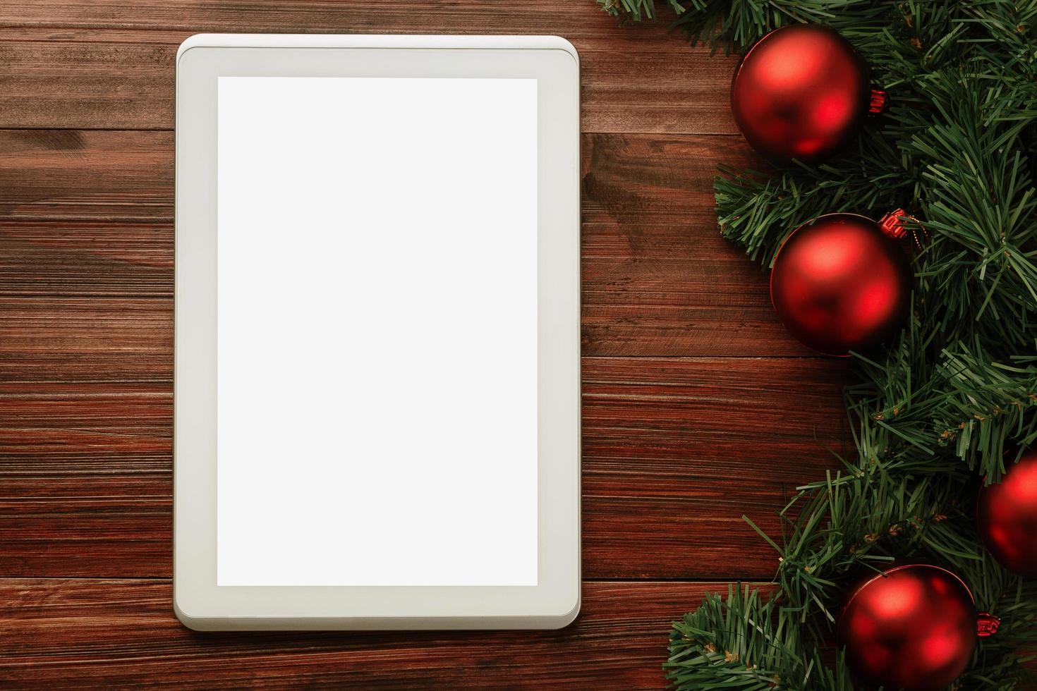 Frohe Weihnachten Tablet-Computer-Modell Vorlage mit Kiefernblättern Dekorationen foto