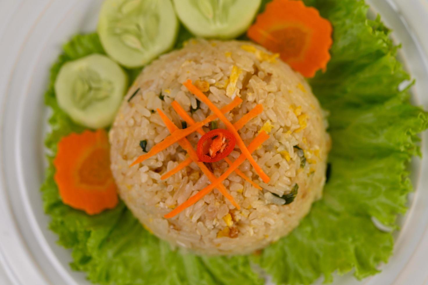 gebratener Reis auf einem weißen Teller mit Salat und Beilage foto