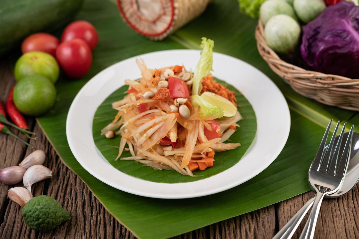 thailändischer Papayasalat mit Bananenblättern und frischen Zutaten foto