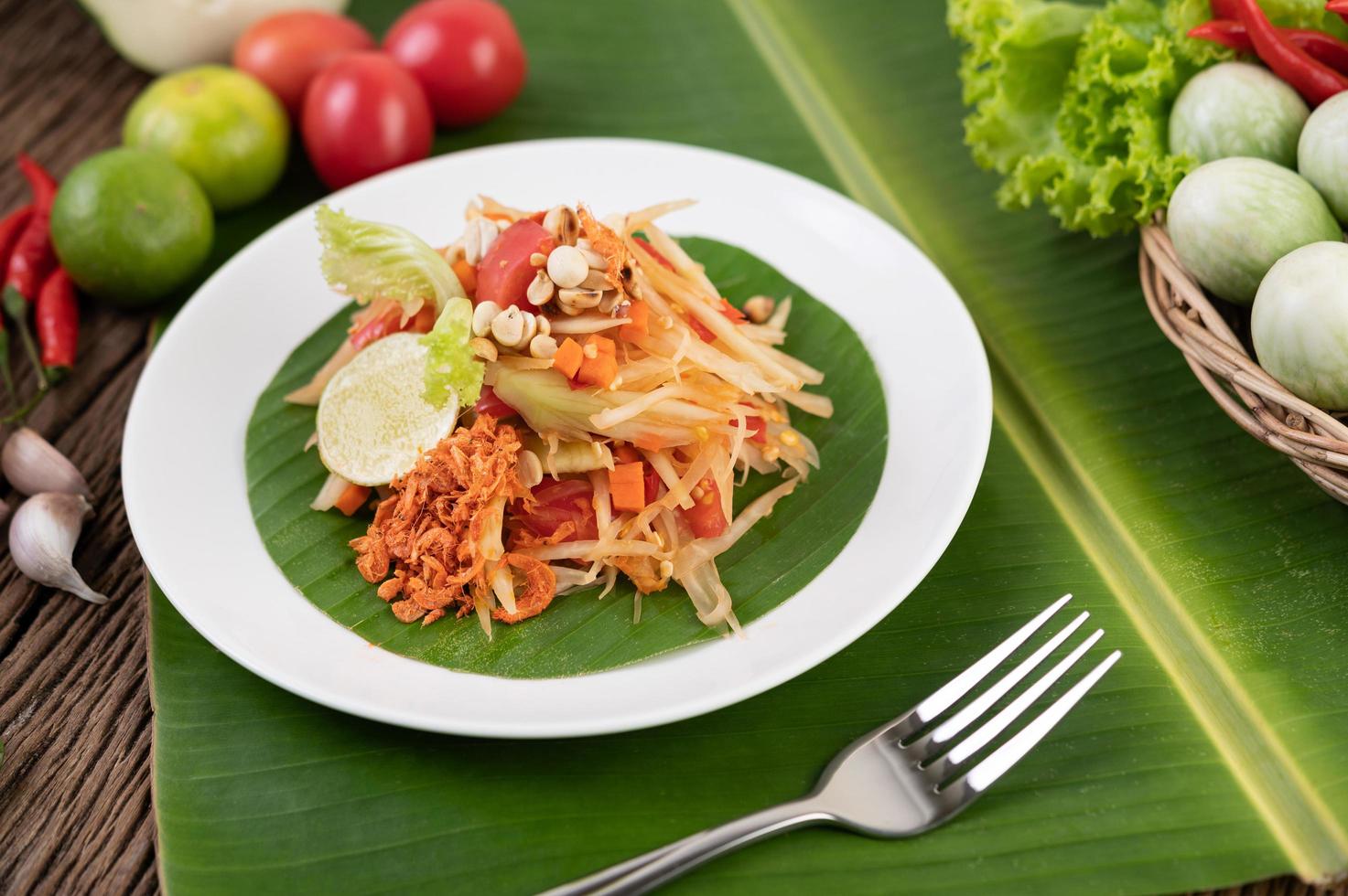 thailändischer Papayasalat mit Bananenblättern und frischen Zutaten foto