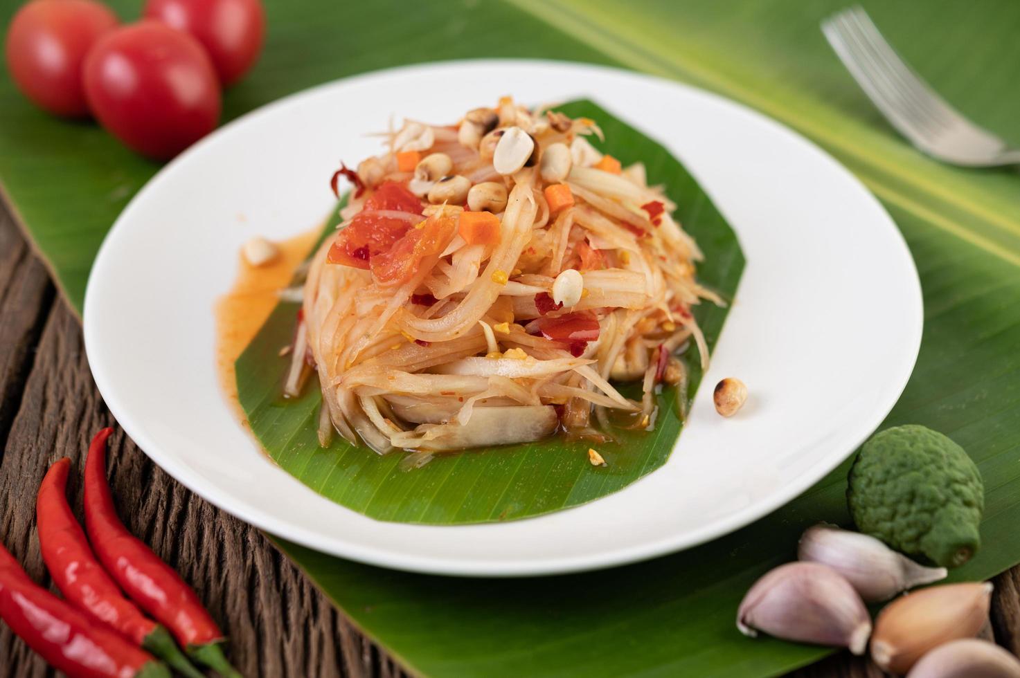 thailändischer Papayasalat mit Bananenblättern und frischen Zutaten foto