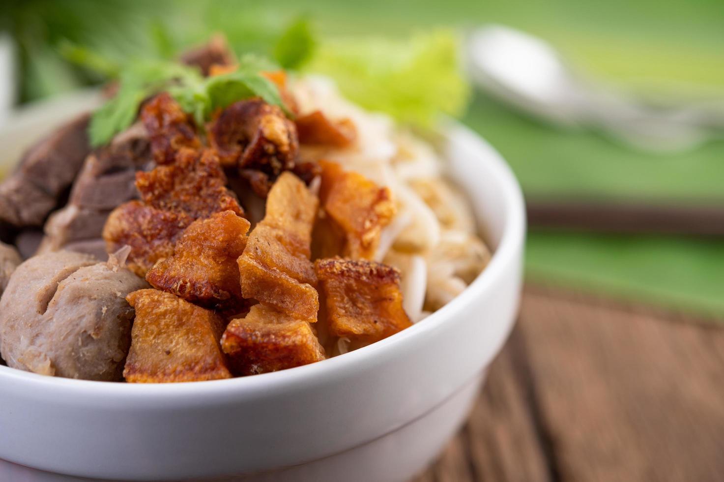 gelbe Nudeln mit knusprigem Schweinefleisch und Fleischbällchen foto