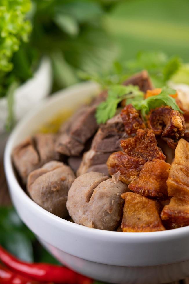 gelbe Nudeln mit knusprigem Schweinefleisch und Fleischbällchen foto