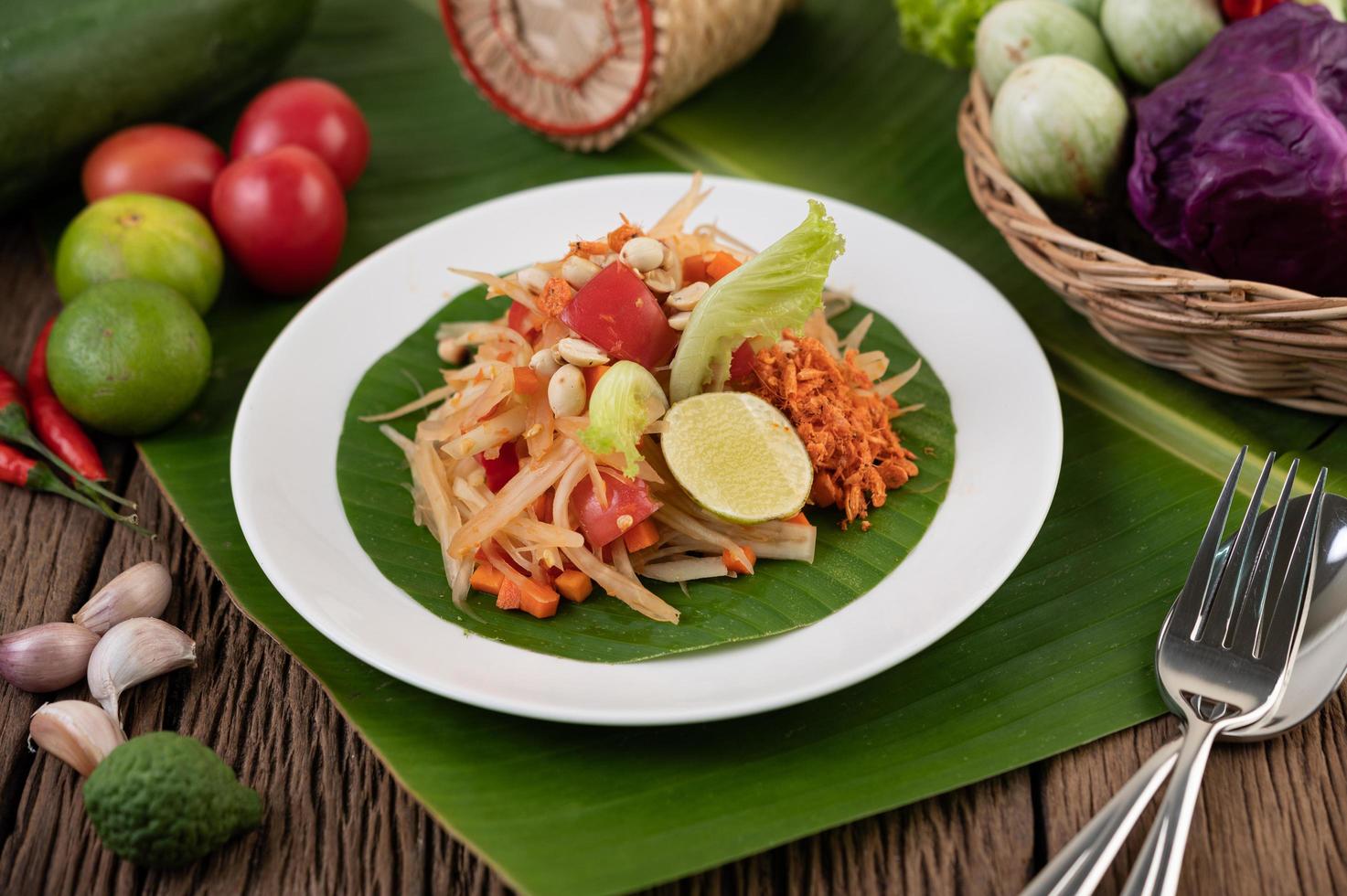 thailändischer Papayasalat mit Bananenblättern und frischen Zutaten foto