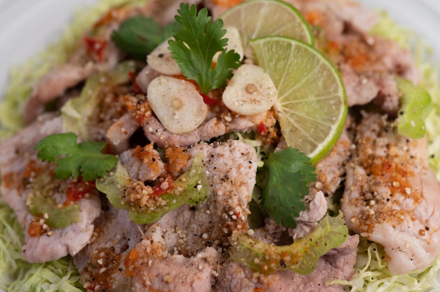 würziger Limettenschweinefleischsalat mit Galangal, Chili und Tomaten foto