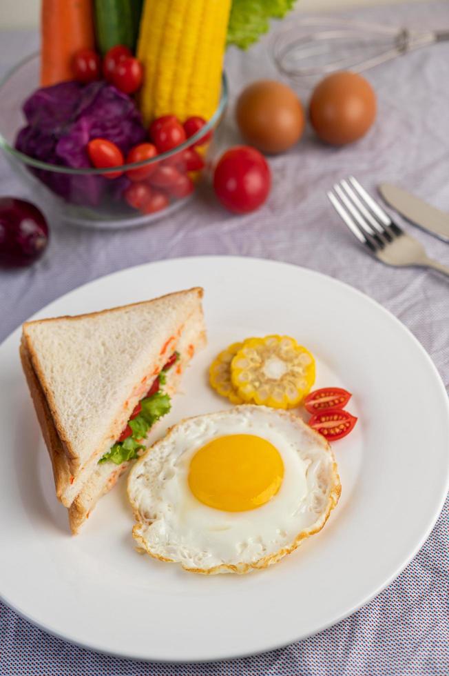 Spiegelei-Frühstück mit Ei, Salat, Kürbis, Gurke, Karotte und Mais foto