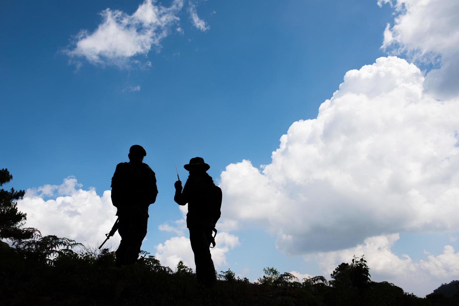 militärische Silhouetten von Soldaten mit vorbereiteten Waffen foto