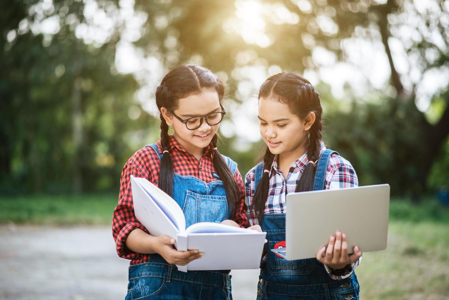 zwei Mädchen studieren und reden in einem Park miteinander foto