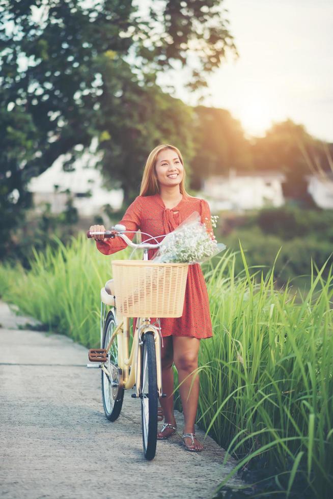 junge asiatische Frau, die Fahrrad in einem Park reitet foto