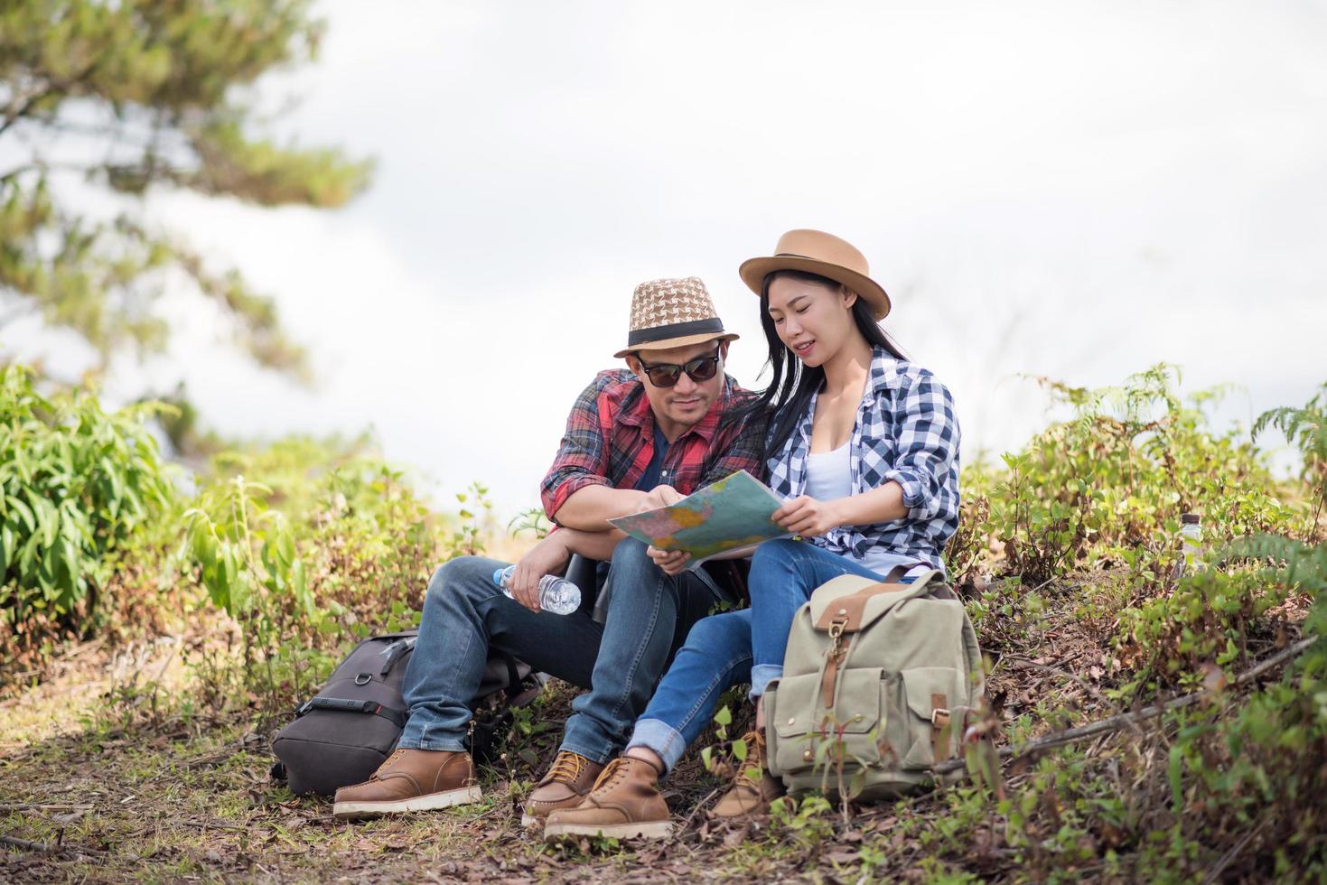 junges Paar, das Karte beim Wandern im Wald betrachtet foto
