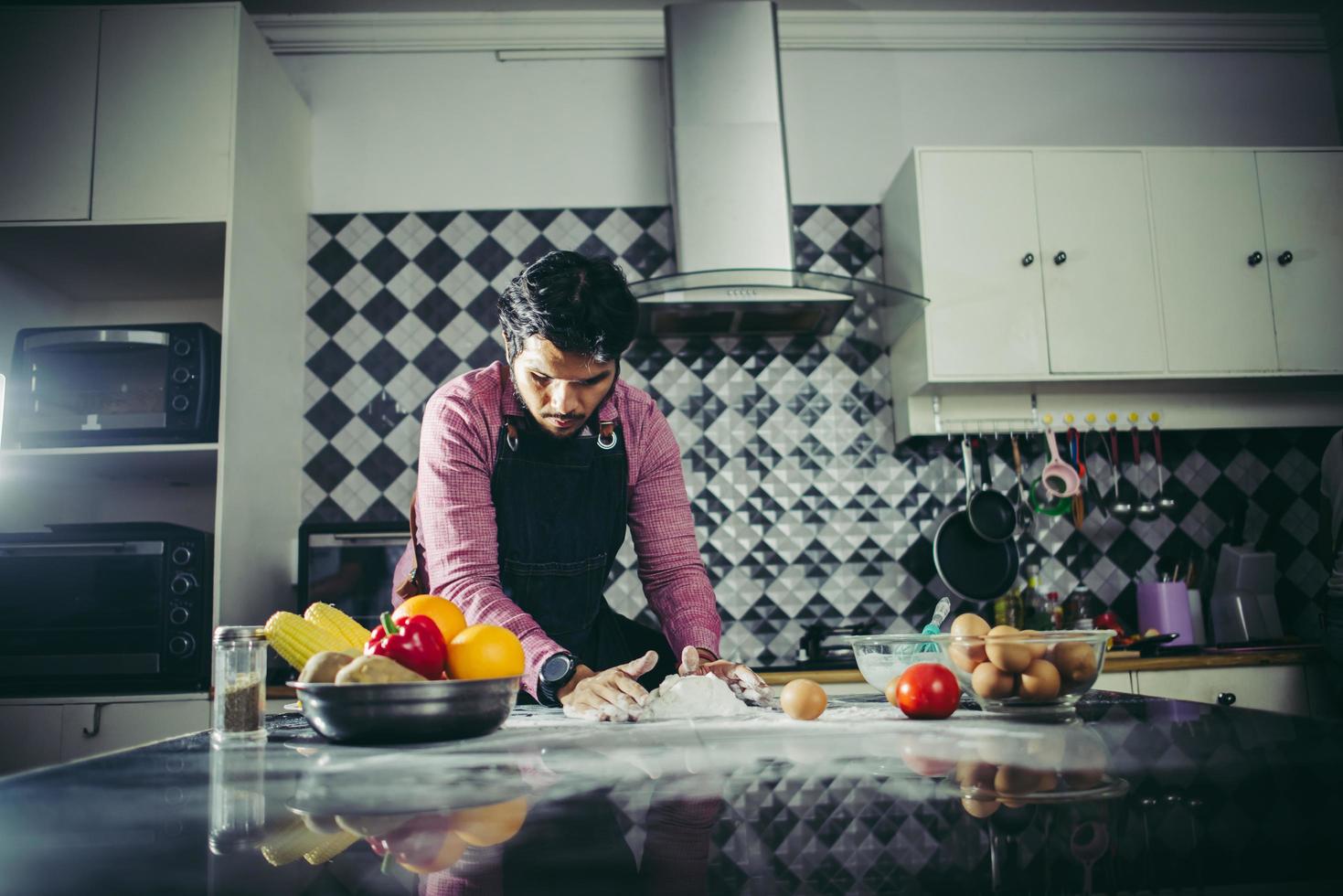 Mann knetete hausgemachten Pizzateig in der Küche foto