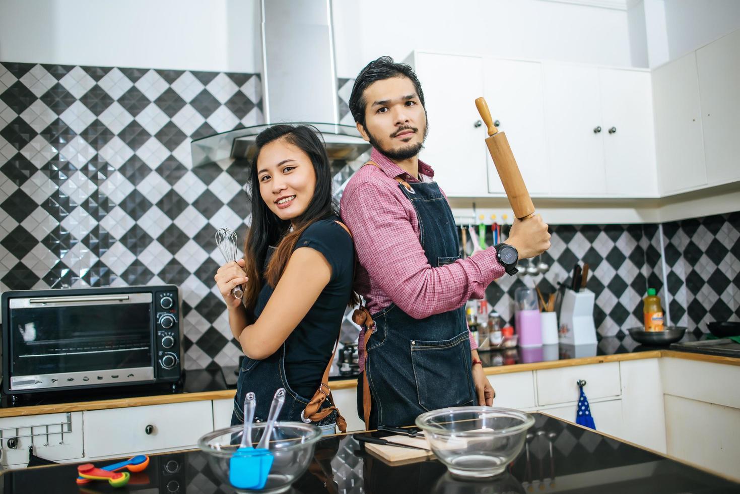 attraktives Paar, das in der Küche zu Hause kocht foto