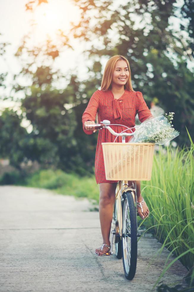 junge asiatische Frau, die Fahrrad in einem Park reitet foto