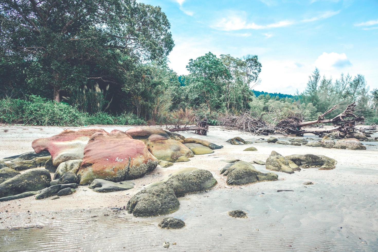 Felsen am Strand mit bewölktem blauem Himmel foto