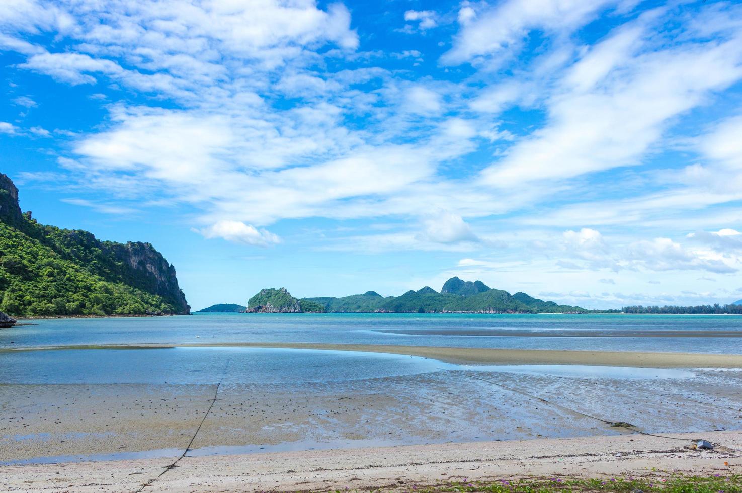 Strand und Berge gegen bewölkten blauen Himmel foto