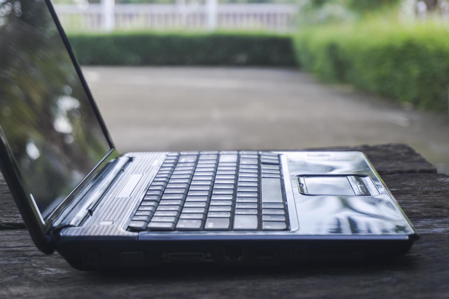 schwarzer Computer-Laptop leer auf einem Holztisch foto