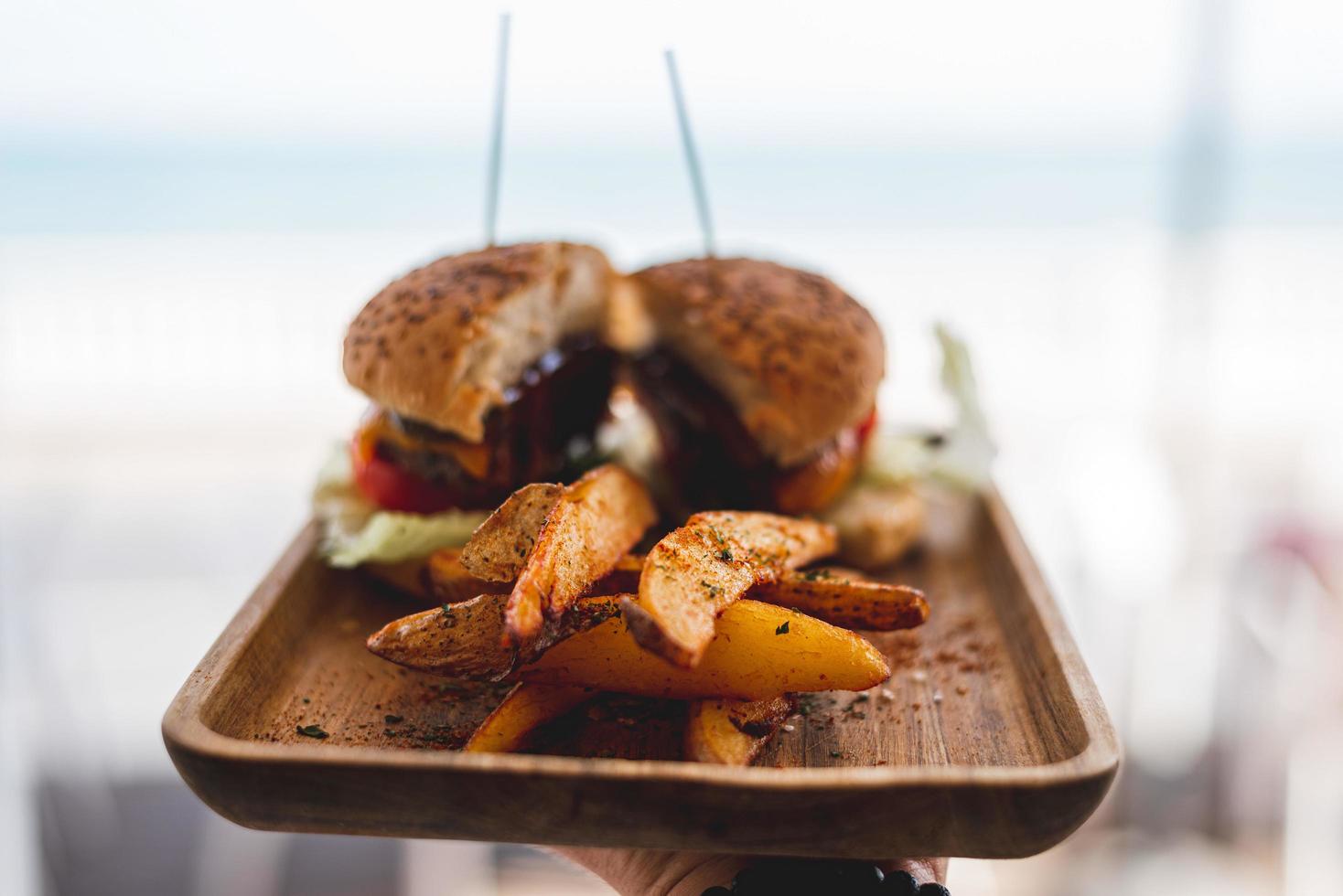 Burger mit Pastetchen und Käse auf braunem Holztablett foto