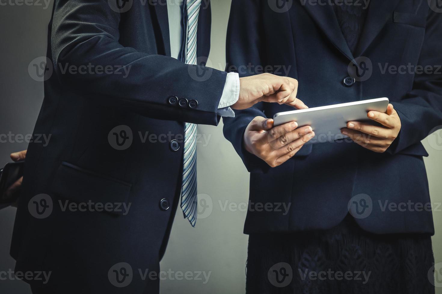 zwei Geschäftsleute, die eine Tablette betrachten foto