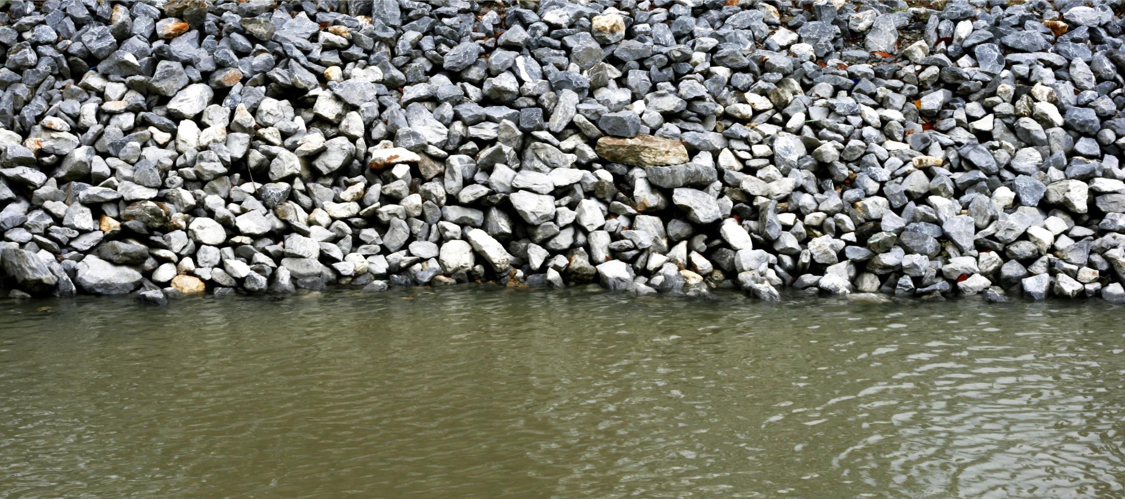 Steinmauer am Ufer des Wassers foto