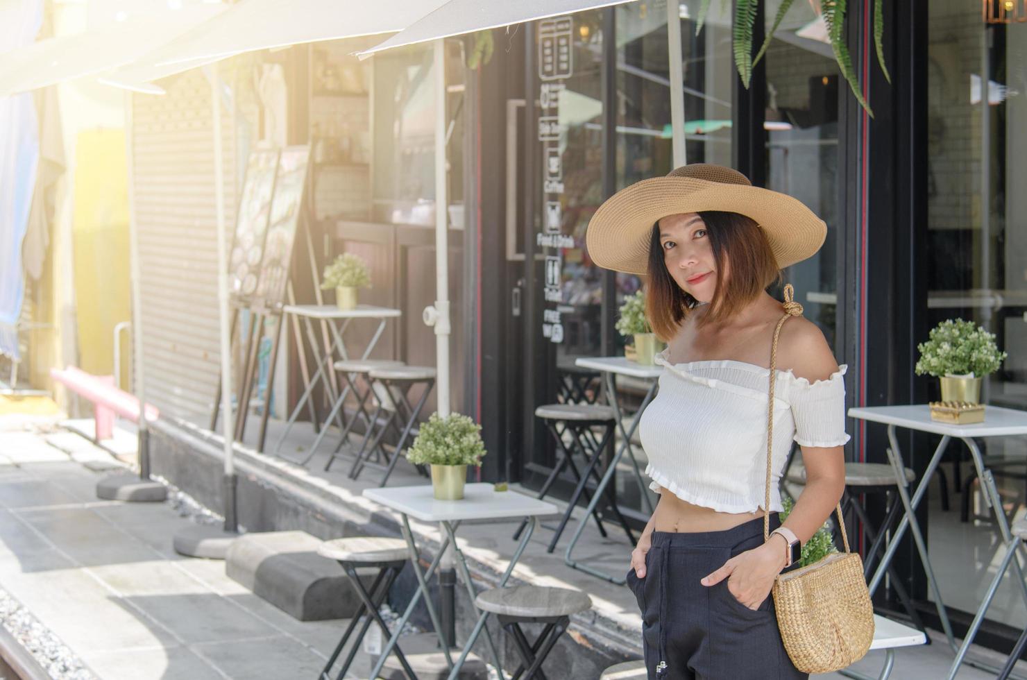 asiatische Frau, die außerhalb eines Cafés aufwirft foto