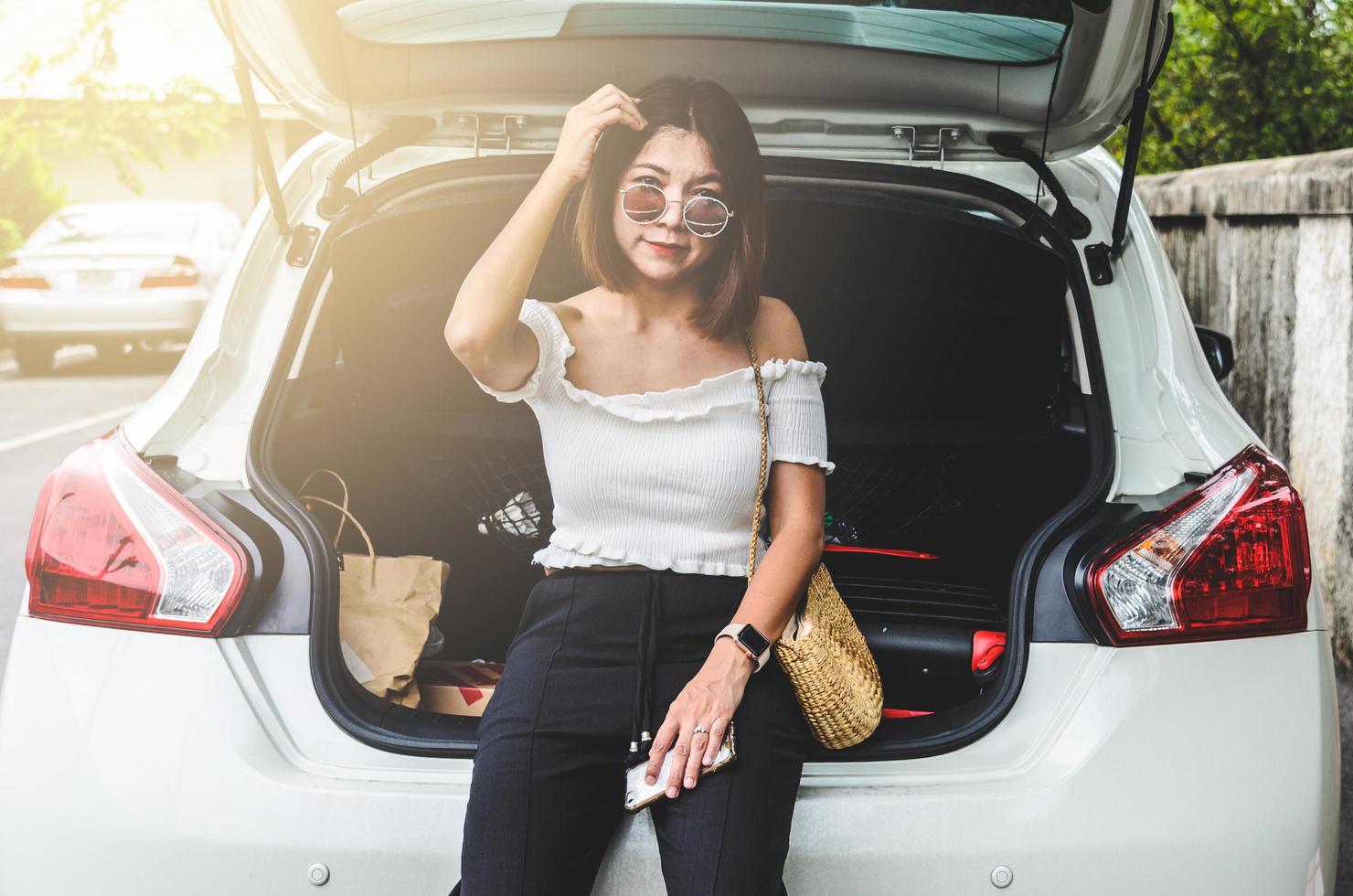 Frau sitzt hinter dem Auto foto