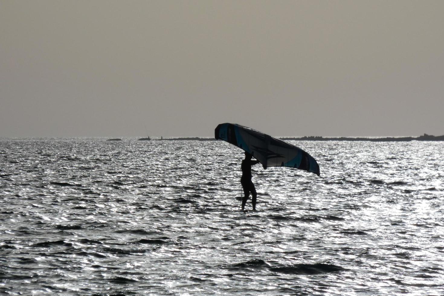 Windsurfen, Kitesurfen, Wasser- und Windsport mit Segeln oder Drachen foto