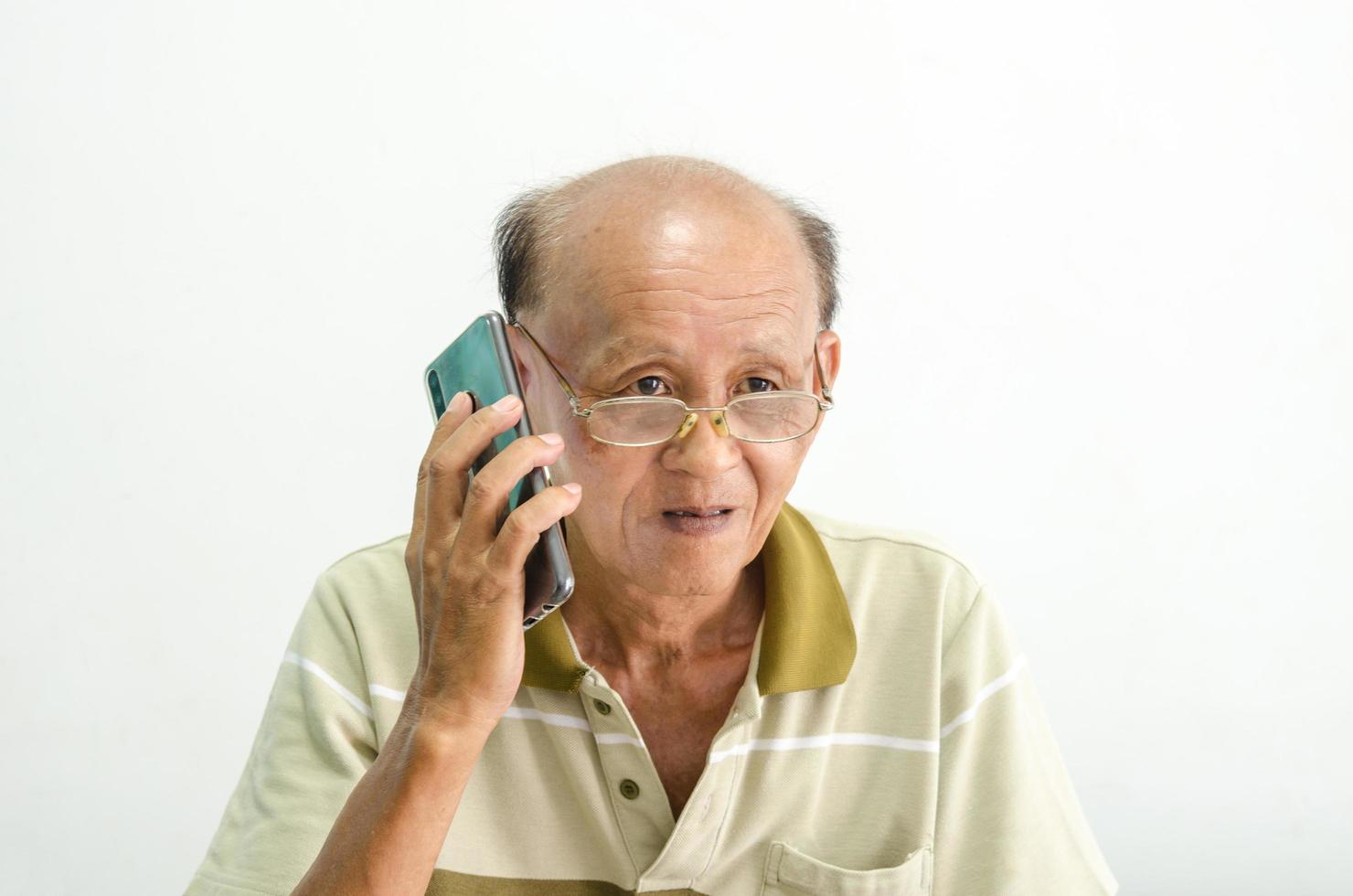 alter asiatischer Mann, der am Telefon spricht foto