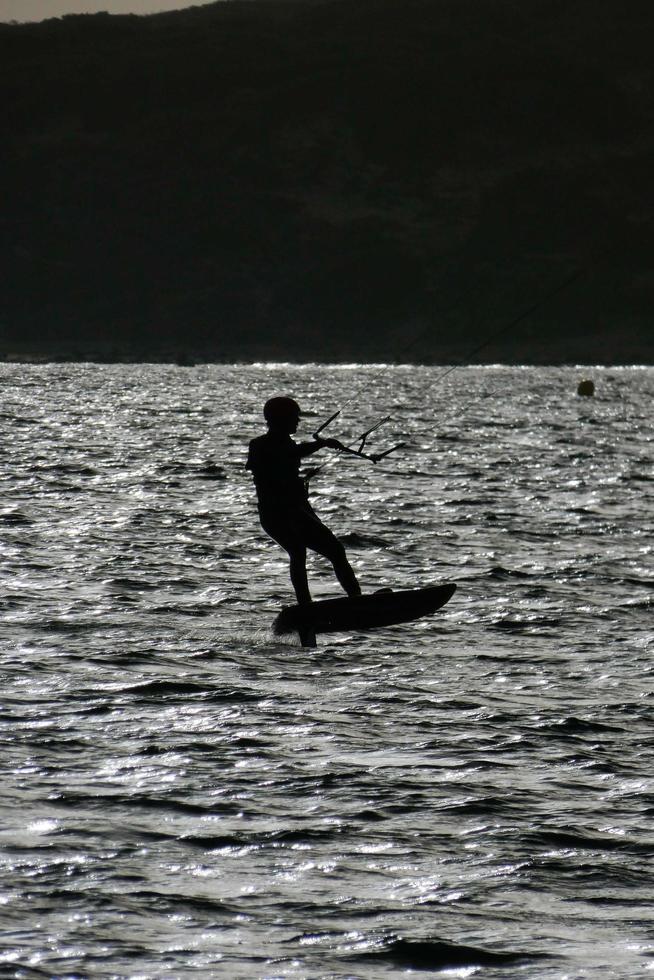 Windsurfen, Kitesurfen, Wasser- und Windsport mit Segeln oder Drachen foto