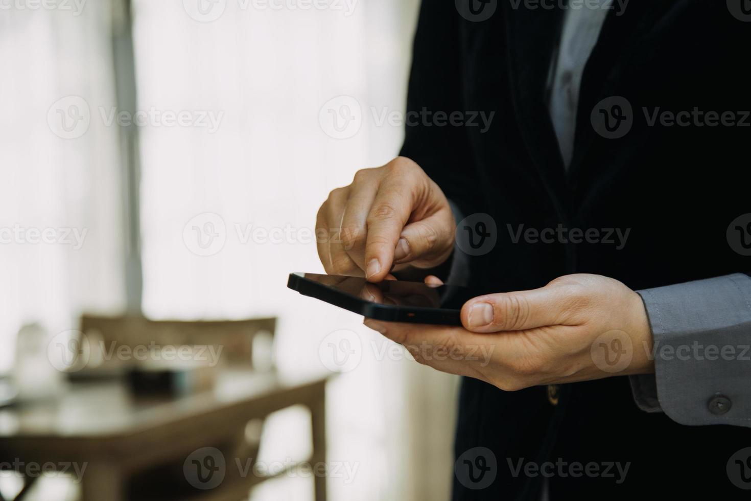 Reifer Geschäftsmann, der ein digitales Tablet verwendet, um Informationen mit einem jüngeren Kollegen in einer modernen Business-Lounge zu besprechen foto