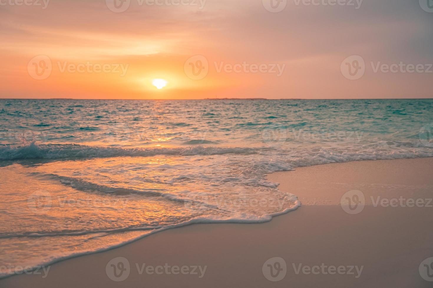 leerer Strand bei Sonnenuntergang. idyllische tropische Strandlandschaft für Hintergrund oder Tapete. sanfte Wellen, die an der Küste plätschern, Sonnenreflexion, friedliche Aussicht. design des sommerferienferienkonzepts. foto