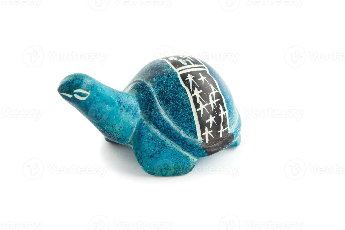 Figur einer Schildkröte aus Stein mit Schnitzereien auf der Schale auf weißem Hintergrund. foto
