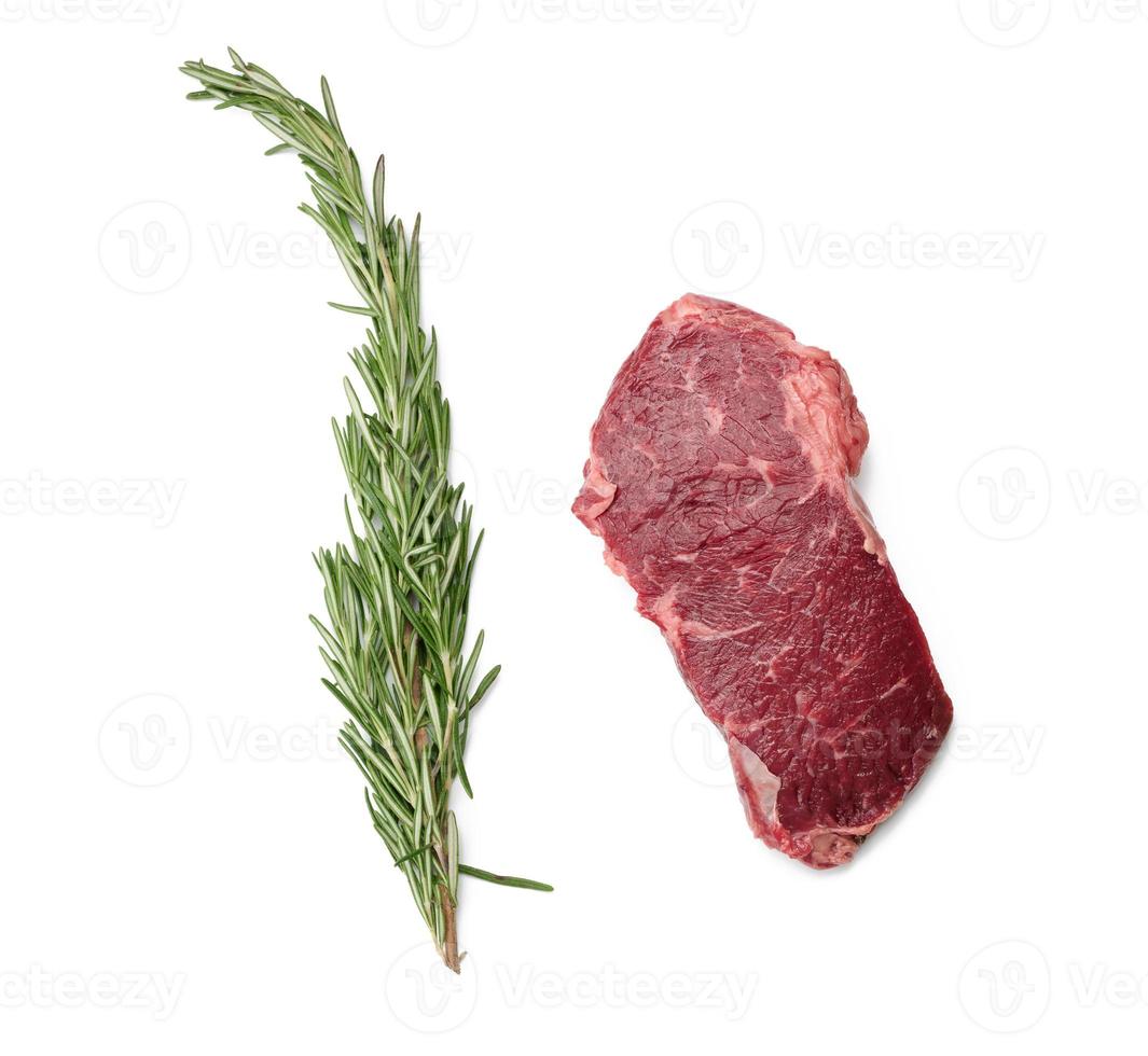 Rohes Stück Rindfleisch Ribeye mit Rosmarin auf einem weißen, isolierten Hintergrund, Draufsicht foto