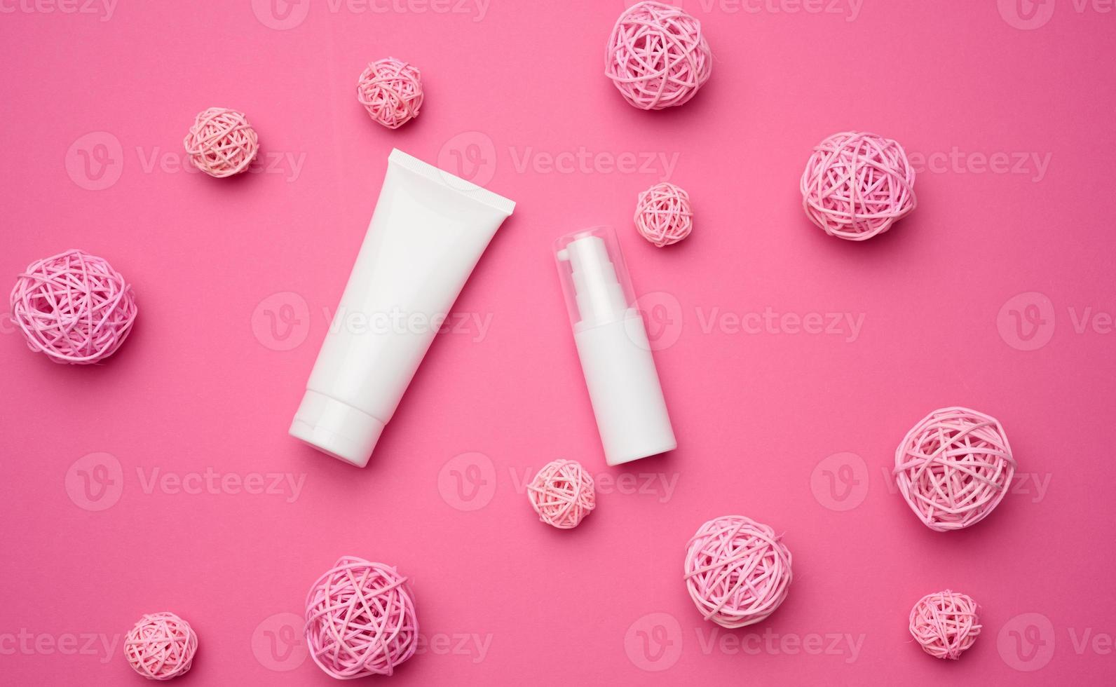 flasche und leere weiße plastikrohre für kosmetik auf rosa hintergrund. Verpackung für Creme, Gel, Serum, Werbung und Produktwerbung, Attrappe foto