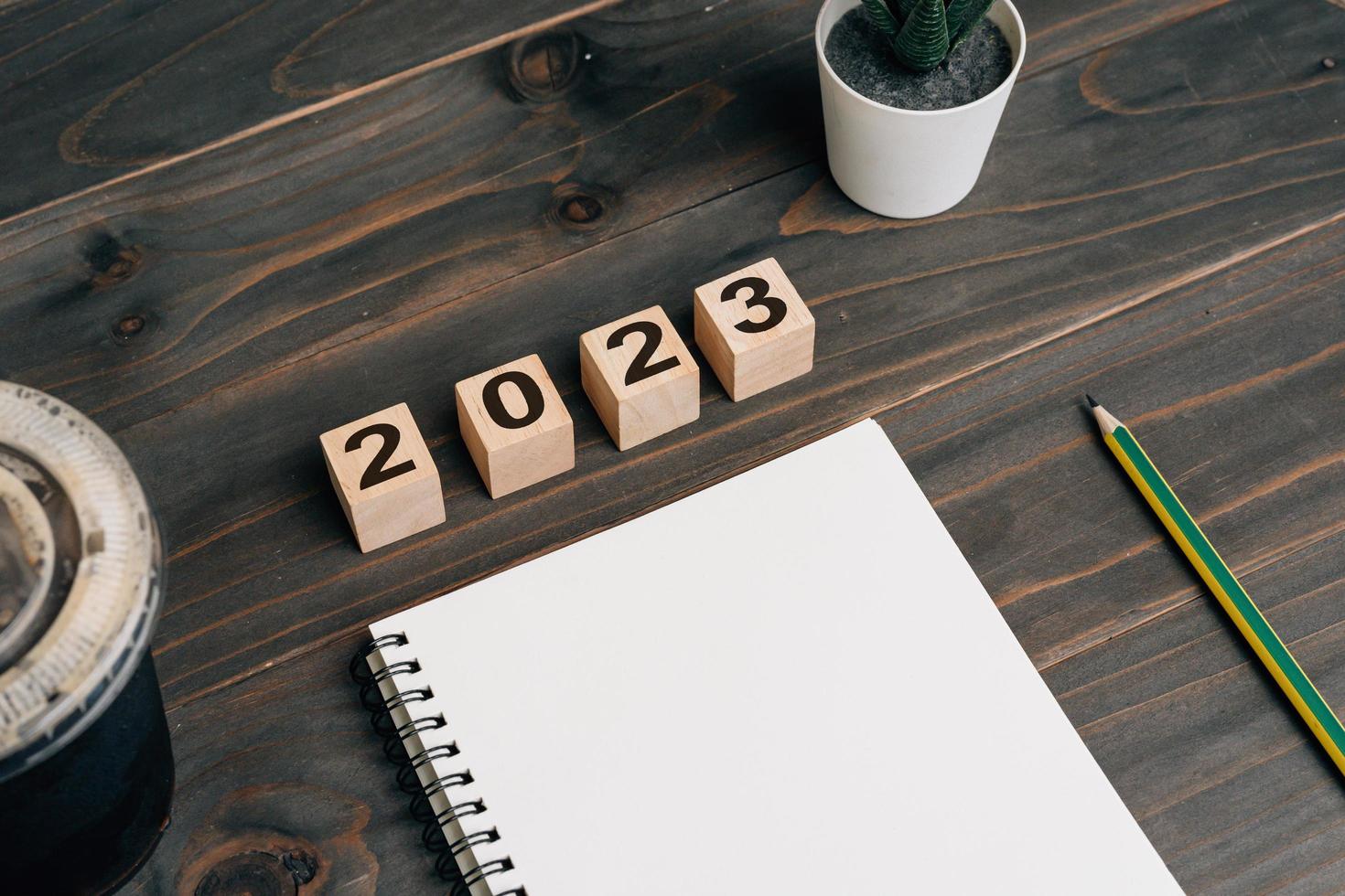 2023 für Ziele Text auf Notizblock leer mit Kaffeetasse und Stift auf Holzschreibtisch foto