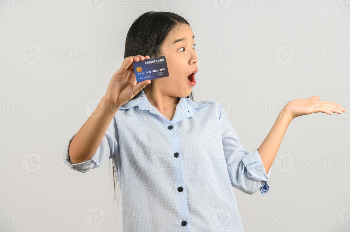 Porträt der positiven jungen asiatischen Frau, die das gute Launegehalt der Kreditkarte lokalisiert auf weißem Hintergrund zeigt foto