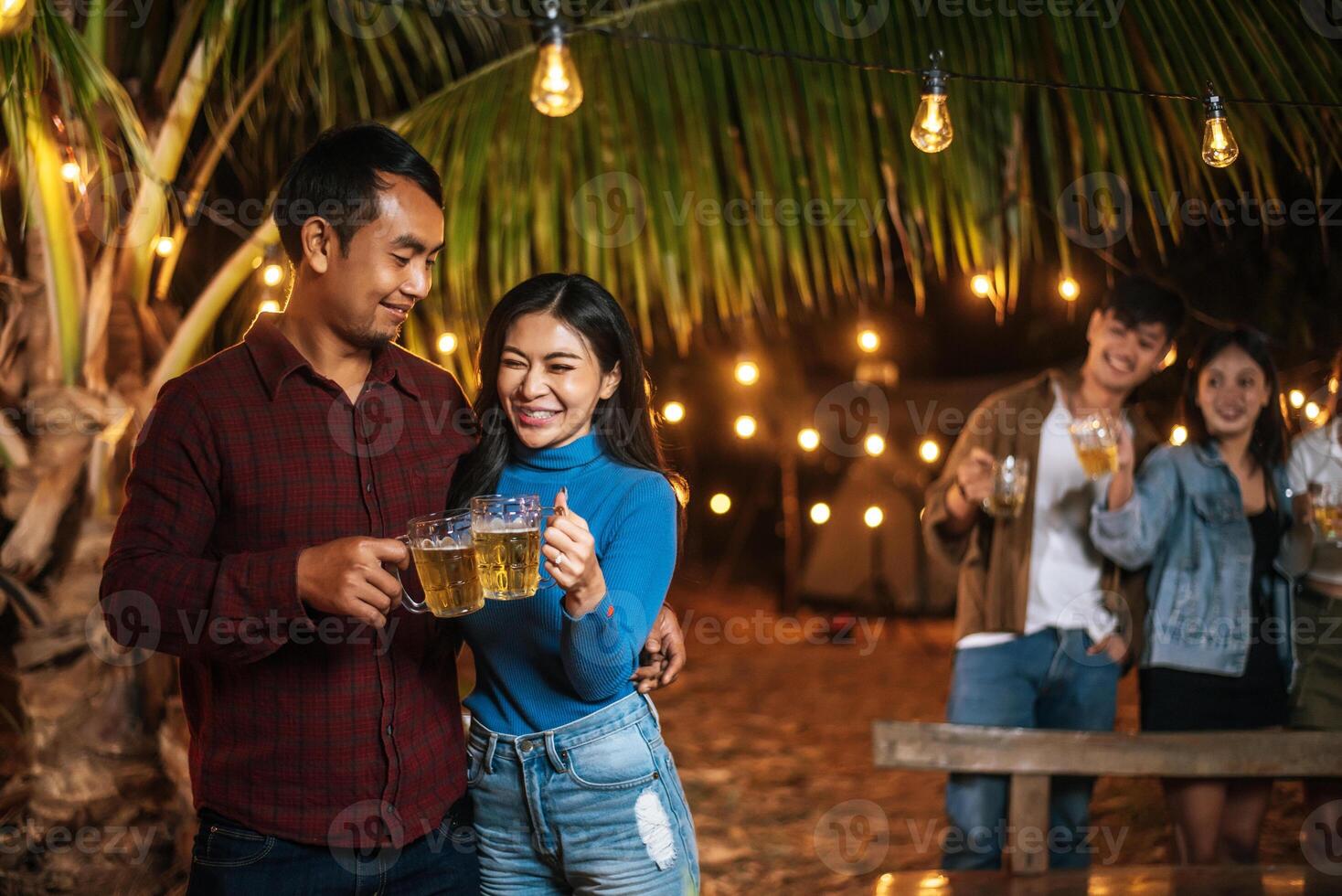 porträt glücklicher asiatischer freunde, die zusammen eine dinnerparty haben - junge leute, die biergläser abendessen im freien anstoßen - menschen, essen, trinken lebensstil, neujahrsfeierkonzept. foto