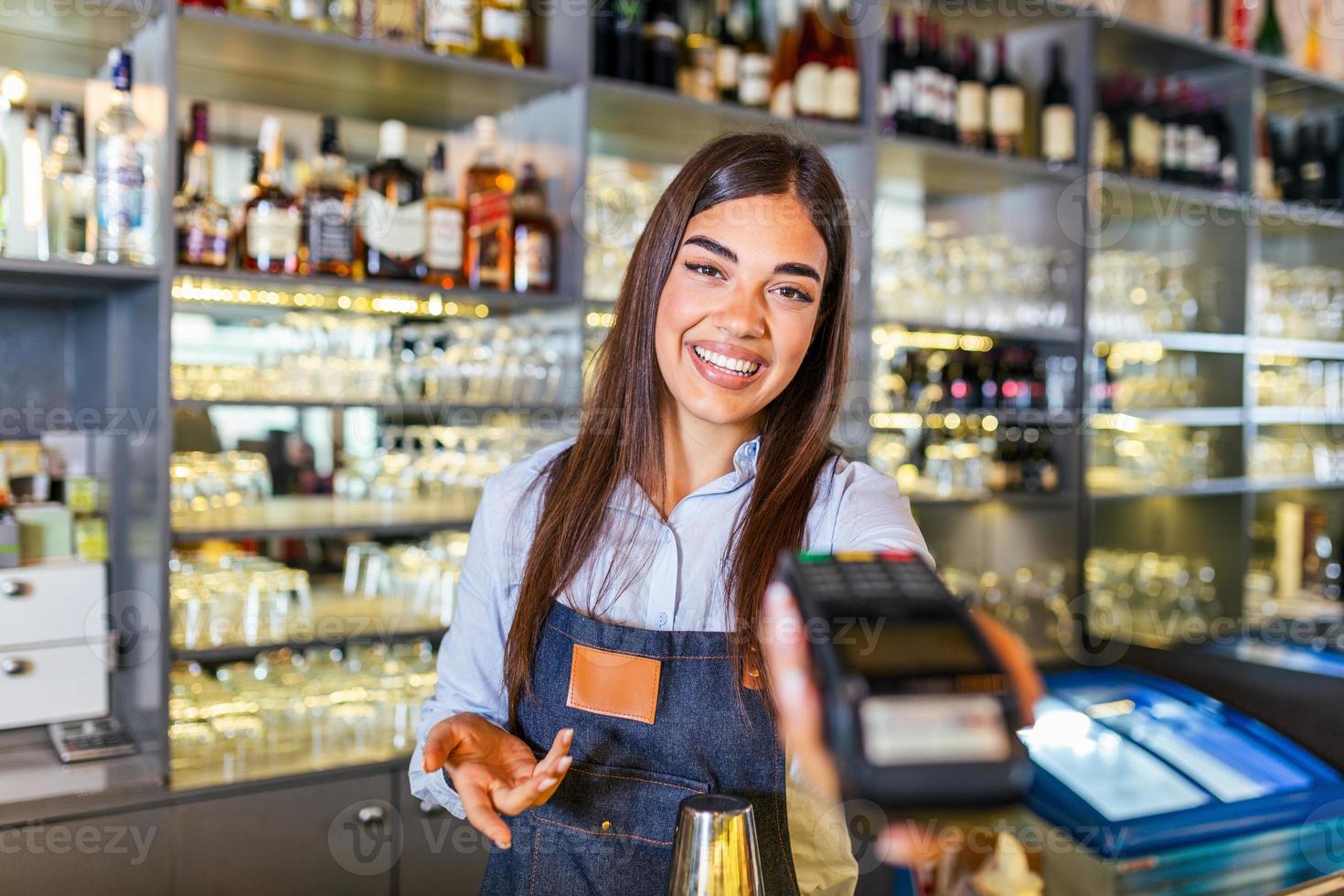 kontaktloses zahlungskonzept, weibliche holding terminal nfc-technologie am schalter, kunden machen transaktion zahlen rechnung auf terminal rfid-kassenmaschine im restaurantgeschäft, nahansicht foto