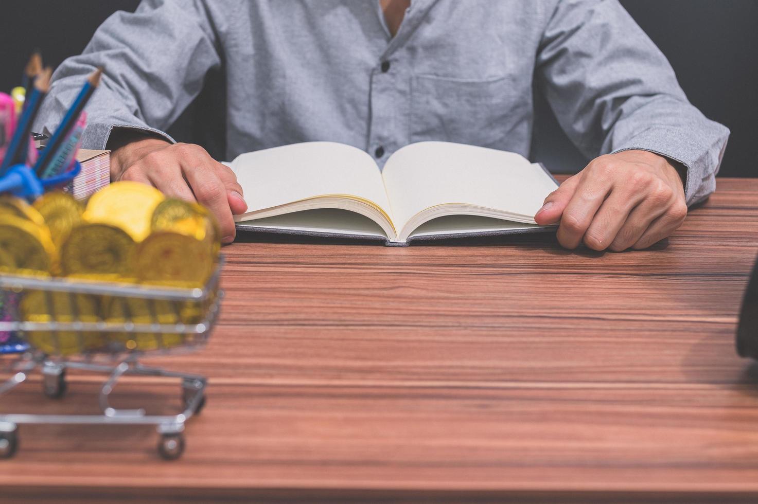 Mann liest ein Buch an seinem Schreibtisch foto