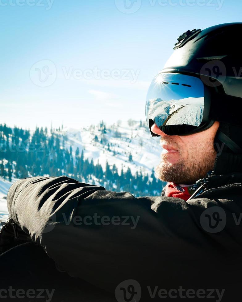nahaufnahme porträt kerl mit snowboard im winter, sportbekleidung, helm, sonnenbrille, winter, oben, freiheit, natur, attraktiv, kleidung, sport, wettkämpfe, winterferien, alpen. foto