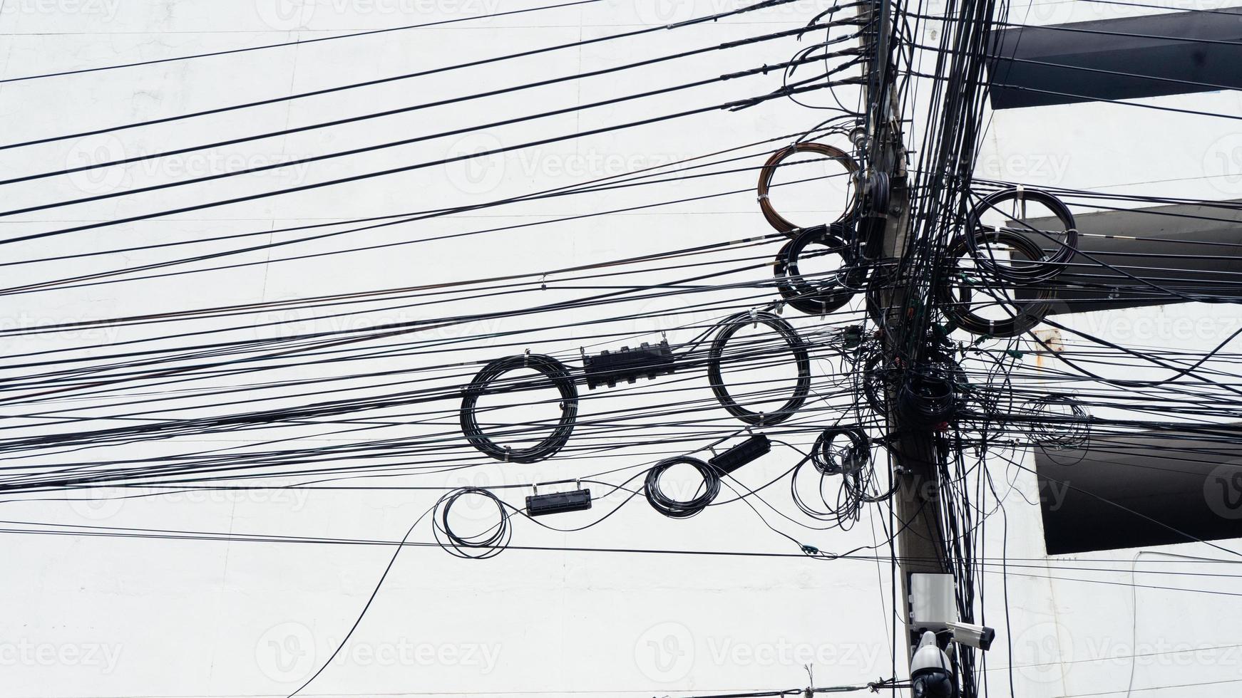 Signalleitungskabel verheddert sich auf der Stange der chaotischen Leitung auf der elektrischen Stange auf der Fußgängerzone, verhedderter elektrischer Draht auf der thailändischen Straße foto