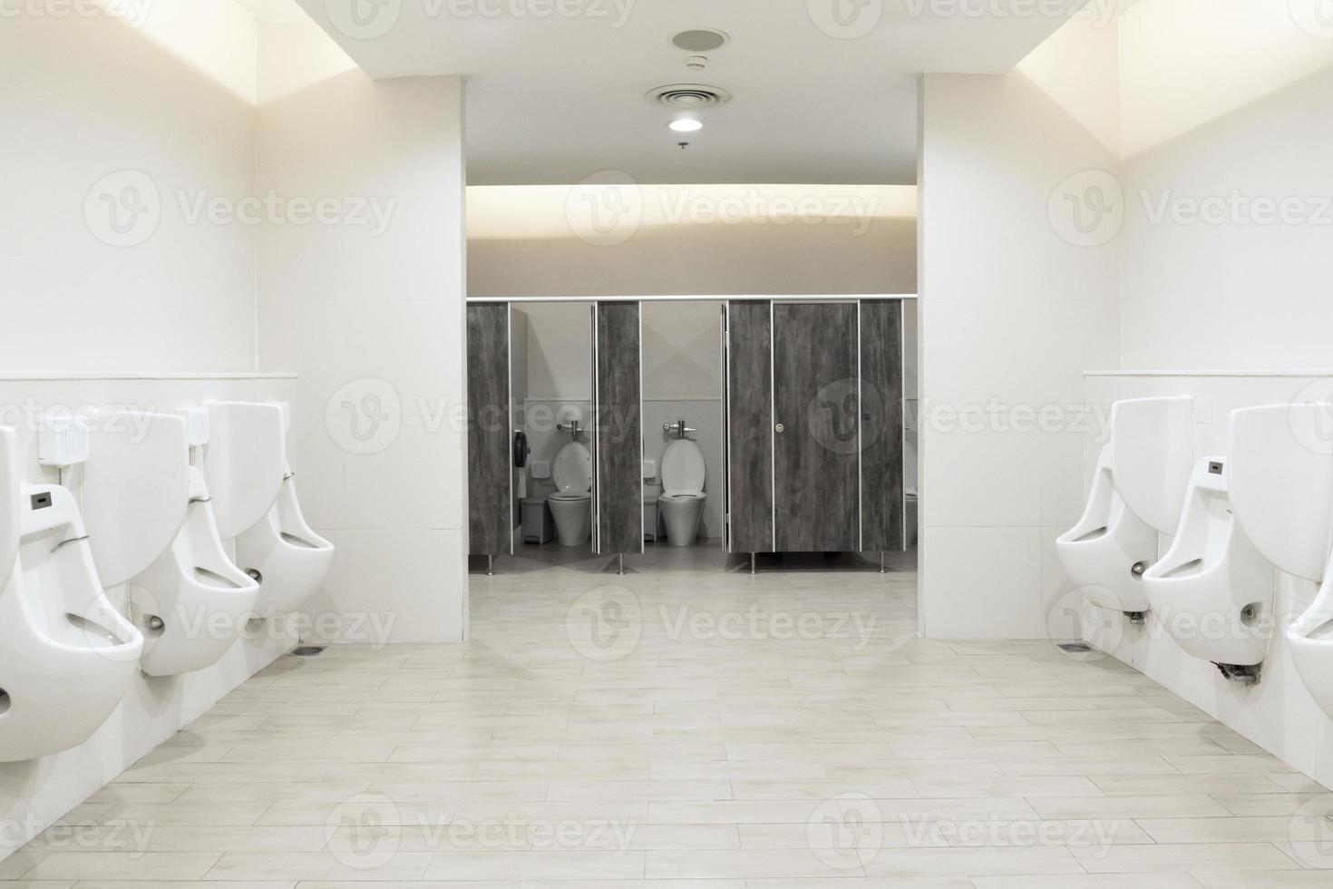 Urinale im Herrenzimmer, Toilettenschüssel in einem modernen Badezimmer mit Mülleimern und Toilettenpapier, Toilettenspülung, sauberes Badezimmer foto