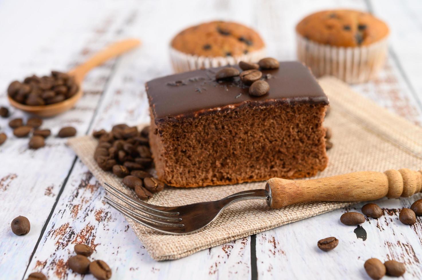 Schokoladenkuchen und Kaffeebohnen mit einer Gabel foto