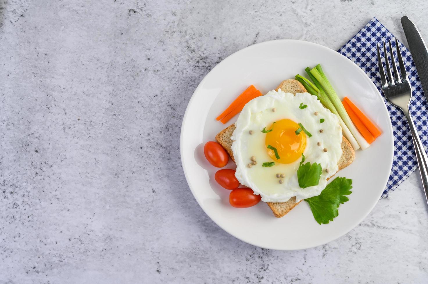 ein Spiegelei auf Toast mit Pfeffersamen, Karotten und Frühlingszwiebeln foto