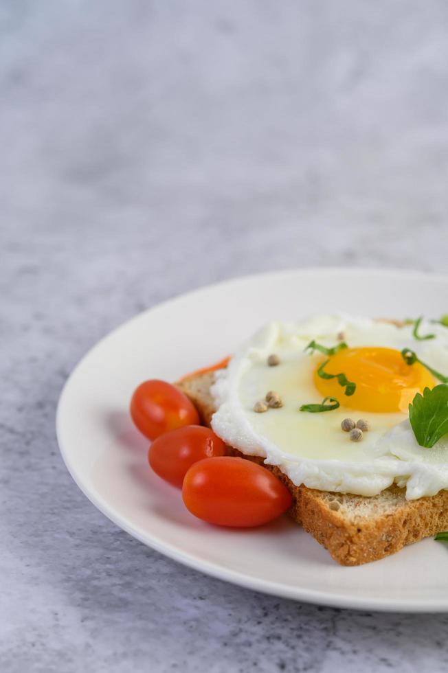 ein Spiegelei auf Toast mit Pfeffersamen, Karotten und Frühlingszwiebeln foto